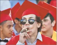  ?? Catherine Avalone / Hearst Connecticu­t Media ?? Branford Town Hall is reflected in the sunglasses of Pasquale Candela as he smokes a cigar following graduation Tuesday on the Green.