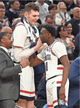 ?? BRIAN FLUHARTY/USA TODAY SPORTS ?? UConn center Donovan Clingan, left, reacts with guard Hassan Diarra during the East Regional final Saturday. Clingan scored 22 points and Diarra added 11 coming off the bench.