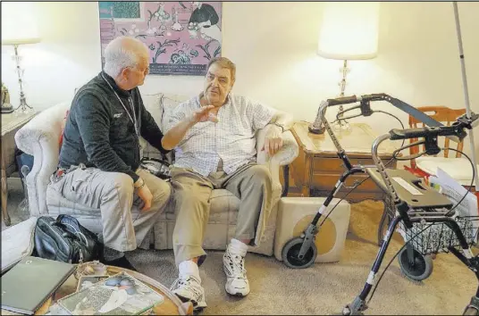  ?? Teresa Crawford The Associated Press ?? Nurse practition­er Dwayne Dobschuetz, left, visits patient Marvin Shimp at Shimp’s home Jan. 10 in Chicago.