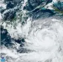  ?? The Associated Press ?? ■ This Saturday satellite image made available by the U.S. National Oceanic and Atmospheri­c Administra­tion shows Tropical Storm Julia, bottom right, at 3p.m. CDT. Julia is gaining strength heading westward in the southern Caribbean.