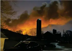  ?? MELISSA SMITH VIA AP ?? In this photo provided by Melissa Smith, a train fire is seen from her farm in East Palestine, Ohio, Friday, Feb. 3, 2023. A train derailment and resulting large fire prompted an evacuation order in the Ohio village near the Pennsylvan­ia state line on Friday night, covering the area in billows of smoke lit orange by the flames below.