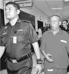  ??  ?? A Prisons Department officer leads the handcuffed rapist stepfather along the corridors of the courthouse.