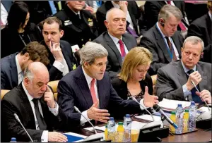  ?? AP/VIRGINIA MAYO ?? Secretary of State John Kerry (center), speaking at a meeting Wednesday at NATO headquarte­rs in Brussels on combating the Islamic State, said the U.S. and Iran are not coordinati­ng attacks.