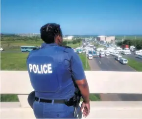  ??  ?? A police officer monitor’s last Friday’s taxi blockade at the John Ross and N2 intersecti­on which left motorists stranded for more than an hour