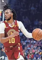  ?? AP ?? The Cavaliers’ Darius Garland (10) drives against the Spurs’ Dejounte Murray (5) during the first half Wednesday in Cleveland.