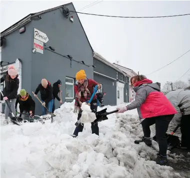  ??  ?? Clockwise from left: Locals take part in the clean-up in Sallins, Co Kildare; Daniel (13), Ali (8) and Callum (10) Dowling on the Kilteel Road, Co Dublin; TV Honan with his grandson Austin Grubb clearing snow on Johns Hill in Waterford city; and...