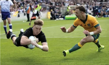  ?? Photograph: Mark Baker/AP ?? New Zealand’s Jordie Barrett, left, scores a try as Australia’s Nic White attempts a tackle during the second Bledisloe Rugby test at Eden Park in October. The cup will continue next week after Wellington granted the Wallabies a travel exemption.