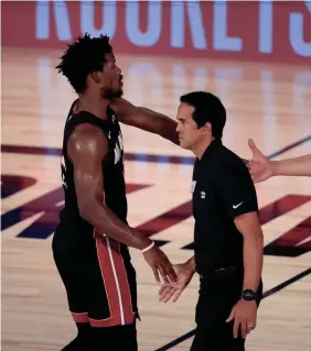  ?? GETTY IMAGES ?? Jimmy Butler shakes hands with Miami coach Erik Spoelstra after their win against the Milwaukee Bucks in Game 1.