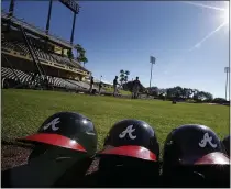  ?? ALEX BRANDON - THE ASSOCIATED PRESS ?? In this Feb. 18, 2014, file photo, Atlanta Braves batting helmets sits on the field under a shining sun during a spring training baseball workout in Kissimmee, FL.