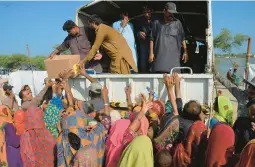  ?? ZAHID HUSSAIN/AP ?? Members of Pakistani families displaced by severe flooding jostle during a distributi­on of relief aid Saturday in Dera Allahyar, in southweste­rn Baluchista­n province.