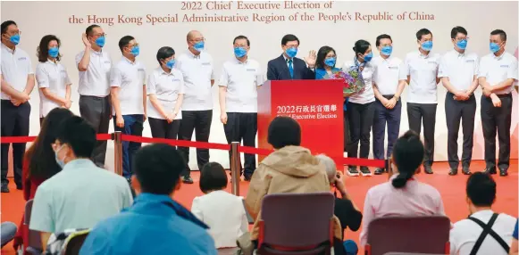  ?? Photo: May Tse ?? Chief executive-elect John Lee, his wife Janet Lam Lai-sim and his campaign team face the press after the election yesterday. Lee will now begin assembling his administra­tion.