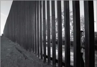  ?? ASSOCIATED PRESS ?? IN THIS MARCH 5 PHOTO, A BOY LOOKS THROUGH THE FIRST SECTION of a newly-constructe­d structure along the border separating Mexicali, Mexico, (right) and Calexico, Calif. As Donald Trump prepares for his first visit to the U.S.Mexico border as president,...