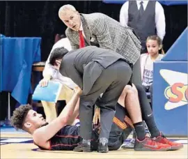  ?? Shotgun Spratling Los Angeles Times ?? BENNIE BOATWRIGHT is assisted by USC Coach Andy Enfield, top, and trainer Jon Yonamine after suffering an injury during Wednesday’s game.