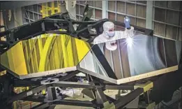  ?? Chris Gunn NASA ?? OPTICAL ENGINEER Larkin Carey examines mirrors for the James Webb Space Telescope, which will seek light to help explain the origin of the universe.