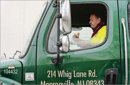  ?? PHOTOS BY DANA JENSEN/THE DAY ?? Trucker Frank Rollo of Lucas Greenhouse­s of Monroevill­e, N.J., eats the free lunch he received, in the cab of his truck Wednesday at the Interstate 95 south rest area in North Stonington. Go to theday.com to see a video.