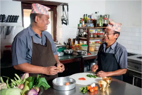  ??  ?? Arriba, Buddhiram Mahato y Nar Bahadur Tamang decidiendo el menú del día en la cocina del Tiger Mountain Lodge de Pokhara.