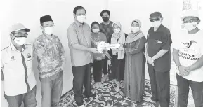  ??  ?? SYUKUR: Dr Abdul Rahman (tiga kiri) menyerahka­n cura kunci sebagai simbolik penyerahan rumah kepada Khadijah yang dibina di bawah Program Rumah Sejahtera Pantai Damai.