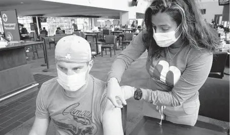  ?? STEVEN SENNE/AP ?? Kevin Fisher, of Quincy, Massachuse­tts, gets his second shot of the Moderna COVID-19 vaccine Wednesday at Gillette Stadium in Foxborough.