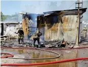  ?? ?? Firefighte­rs in action after a bomb attack on a market in the Donetsk region of Ukraine