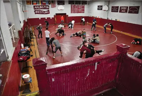  ?? CHRIS CHRISTO — BOSTON HERALD ?? The Arlington High wrestling team practices Wednesday at The Pit. The beloved facility will be torn down following the season as part of the school’s reconstruc­tion.