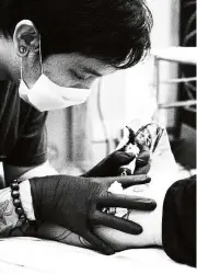  ??  ?? Majakil, wearing one of his signature black Koiyak Gloves, working on a client.