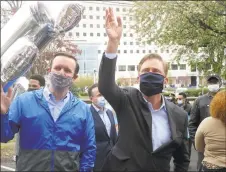  ?? Ned Gerard / Hearst Connecticu­t Media ?? U.S. Sen. Chris Murphy, left, and Gov. Ned Lamont wave to patients inside during a thank you rally in front of Northbridg­e Health Care Center in Bridgeport on May 1. Several elected officials stopped at Northbridg­e to thank the staff, where dozens of COVID-19 patients have been sent for recovery.