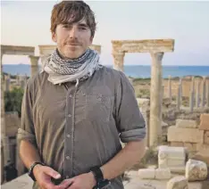  ??  ?? 0 Simon Reeve visits the ruins of the Roman city of Leptis Magna in Libya during his series Mediterran­ean