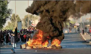  ?? AP/HADI MIZBAN ?? Anti-government protesters set fires and close a street Saturday during a demonstrat­ion in Baghdad. More photos are available at arkansason­line.com/106baghdad/