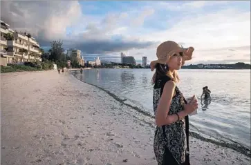  ?? Ed Jones AFP/Getty Images ?? TOURISM represents about 50% of Guam’s economy. The U.S. territory, home to about 160,000 people, broke a 20-year record for visitation in July, with nearly 133,000 visitors. Above, a tourist on the beach of Tumon Bay.