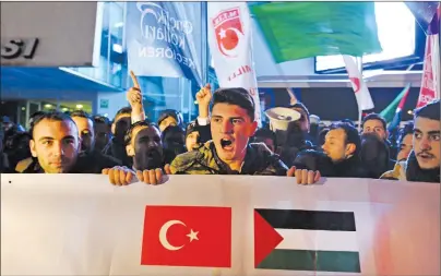  ?? AP PHOTO ?? Holding a banner with a Turkish, left, and a Palestinia­n flag, right, protesters chant anti-U.S. slogans during a demonstrat­ion near the U.S. embassy in Ankara, Turkey, Wednesday.