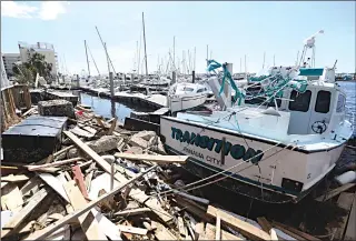 ?? Associated Press photo ?? Boats and dock materials clutter the waterfront in Panama City, Fla.. Residents of this Florida panhandle community are beginning the long process of recovery after being hit with Hurricane Michael.