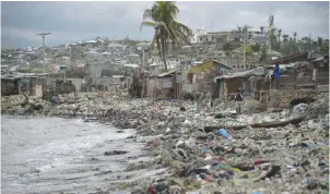  ?? — AFP ?? JEREMIE: View of a beach close to the wharf in Jeremie, Haiti. In the background are seen houses that were damaged by Hurricane Matthew.