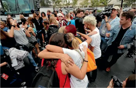  ?? PHOTO: AP ?? Students from Marjory Stoneman Douglas High School hug survivors of the Pulse nightclub shooting before boarding buses in Parkland, Florida to travel to the state capital for a rally calling on the Florida state legislatur­e to consider a package of gun...