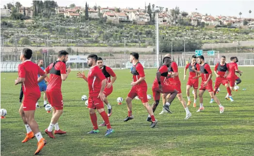  ??  ?? GOOD NEIGHBOURS: Players of the Hapoel Katamon Jerusalem team take part in a training session on a pitch in Jerusalem.