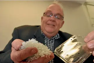  ?? PHOTO: MATTHEW TSO/STUFF ?? Flight Plastics chief executive Keith Smith with a handful of processed PET flakes and a fruit punnet made of recycled material.