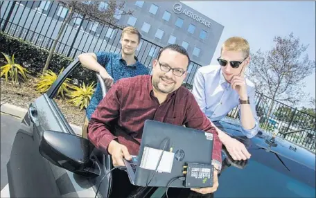  ?? Brian van der Brug Los Angeles Times ?? ENGINEERS, from left, Sebastian Olsen, Andres Vila and Alon Krauthamme­r with a car, computer and antenna used for field testing in El Segundo. Aerospace Corp.’s technology could eventually pull in TV and radio signals or even visual imagery to...