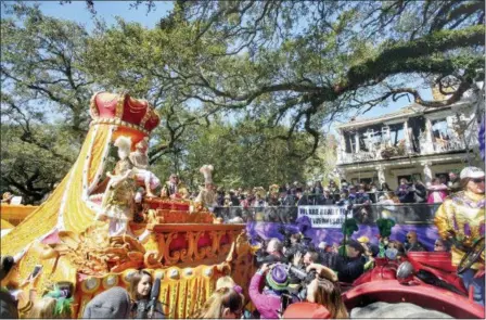  ?? CHRIS GRANGER — THE ADVOCATE VIA AP ?? Rex royalty take an extended pause in front of the charred carcass of a St. Charles Avenue mansion to make a toast, carrying on a tradition that began in 1907, at a house that looms large in krewe and Mardi Gras history in New Orleans, Tuesday.