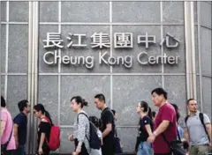  ?? ANTHONY WALLACE/AFP ?? Pedestrian­s walk past signage for Li Ka-shing’s Cheung Kong Center in Hong Kong in August.