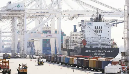  ?? Lea Suzuki / The Chronicle ?? Vehicles drive past containers on trailers next to a ship at the Port of Oakland. About 40% of the port’s income is from the seaport.