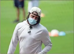  ?? AP - Brynn Anderson ?? Braves reliever Luke Jackson wears a mask as he heads into the dugout during Friday’s workouts.