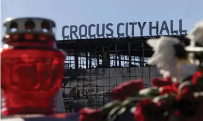  ?? Photograph: Maxim Shemetov/Reuters ?? Candles and flowers lie outside the burned-out Crocus City Hall. Moscow is still accusing Ukraine of being behind the attack.