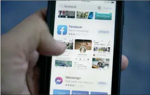  ?? The Associated Press ?? The Facebook app is shown on a smart phone, in Surfside, Fla. As you look through your social media feeds this summer, fear of missing out, or FOMO, can kick in when it seems like everyone you know is strolling through Paris or lounging on a tropical beach.