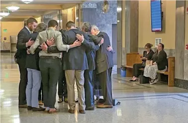  ?? AP PHOTO/TRAVIS LOLLER ?? In Nashville, Covenant School parents and their attorneys huddle in prayer outside a courtroom Wednesday before a hearing to decide whether documents and journals of a Nashville school shooter can be released to the public.