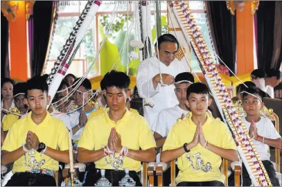  ?? Sakchai Lalit ?? The Associated Press Coach Ekkapol Janthawong, second from left, and members of the rescued soccer team attend a Buddhist ceremony that is believed to extend the lives of its attendees as well as ridding them of dangers and misfortune­s Thursday in Mae Sai, Thailand.