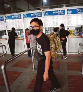  ?? EPA PIC ?? People buying bus tickets at a counter in Bangkok on Friday to return to their hometowns for Songkran.