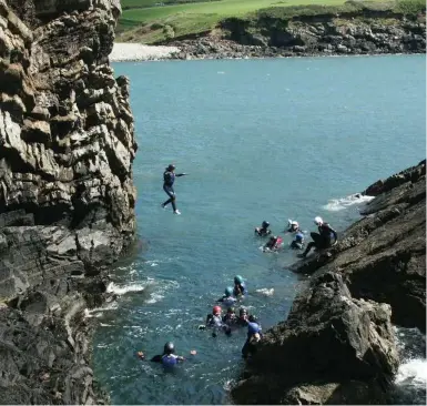  ?? VISIT WALES ?? The highlight of coasteerin­g with outfitter Preseli Venture: free falling into the water.