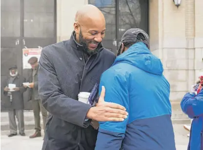  ?? PAT NABONG/SUN-TIMES ?? State Rep. Lamont Robinson, who is running for alderperso­n of the 4th Ward, greets a supporter outside Canter Middle School in Kenwood on Tuesday.