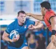  ??  ?? Ryan Ghietti of Italy in the grip of Jason Taumalolo of Tonga.