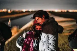  ?? Gregory Bull/Associated Press ?? A couple from Cuba wait to be processed to seek asylum after crossing the border into the United States last month near Yuma, Ariz.