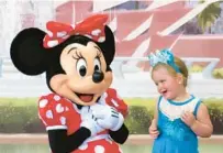  ?? JOE BURBANK/ORLANDO SENTINEL ?? A young guest is welcomed by Minnie Mouse on the opening day of the 2023 Epcot Internatio­nal Flower & Garden Festival at Walt Disney World on Wednesday.